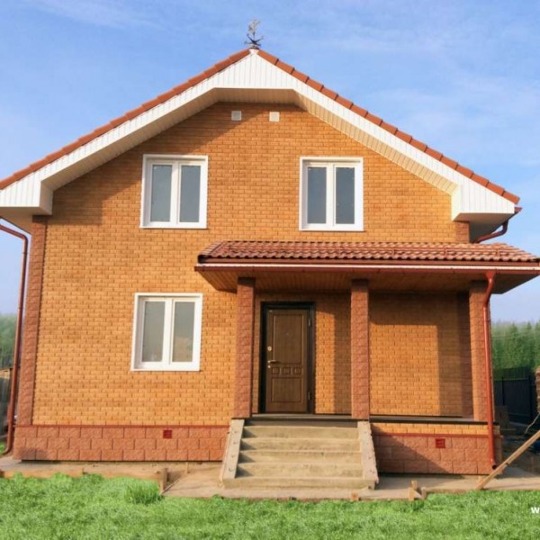 Двухэтажный дом с фасадом из «Сколотого кирпича» терракотового оттенка